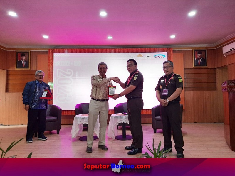 Kajati Kalsel, Dr Mukri menyerahkan cenderamata kepada dua narasumber acara Seminar Nasional. (FOTO:ISTIMEWA)