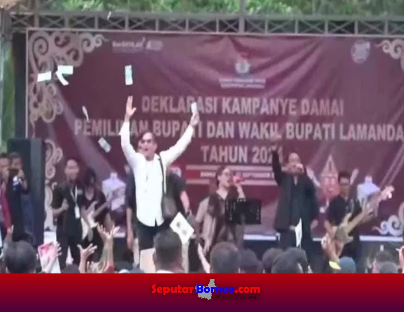 Aksi oknum masyarakat yang menghamburkan uang saat deklarasi kampanye damai di Kabupaten Lamandau, Senin (23/9/2024). FOTO: SCRENSHOT